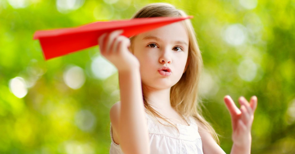 Adorable little girl holding a paper plane Adorable little girl holding a paper plane