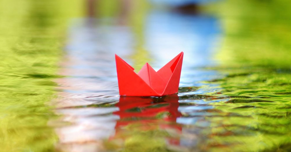 A paper boat floating on a river A paper boat floating on a river